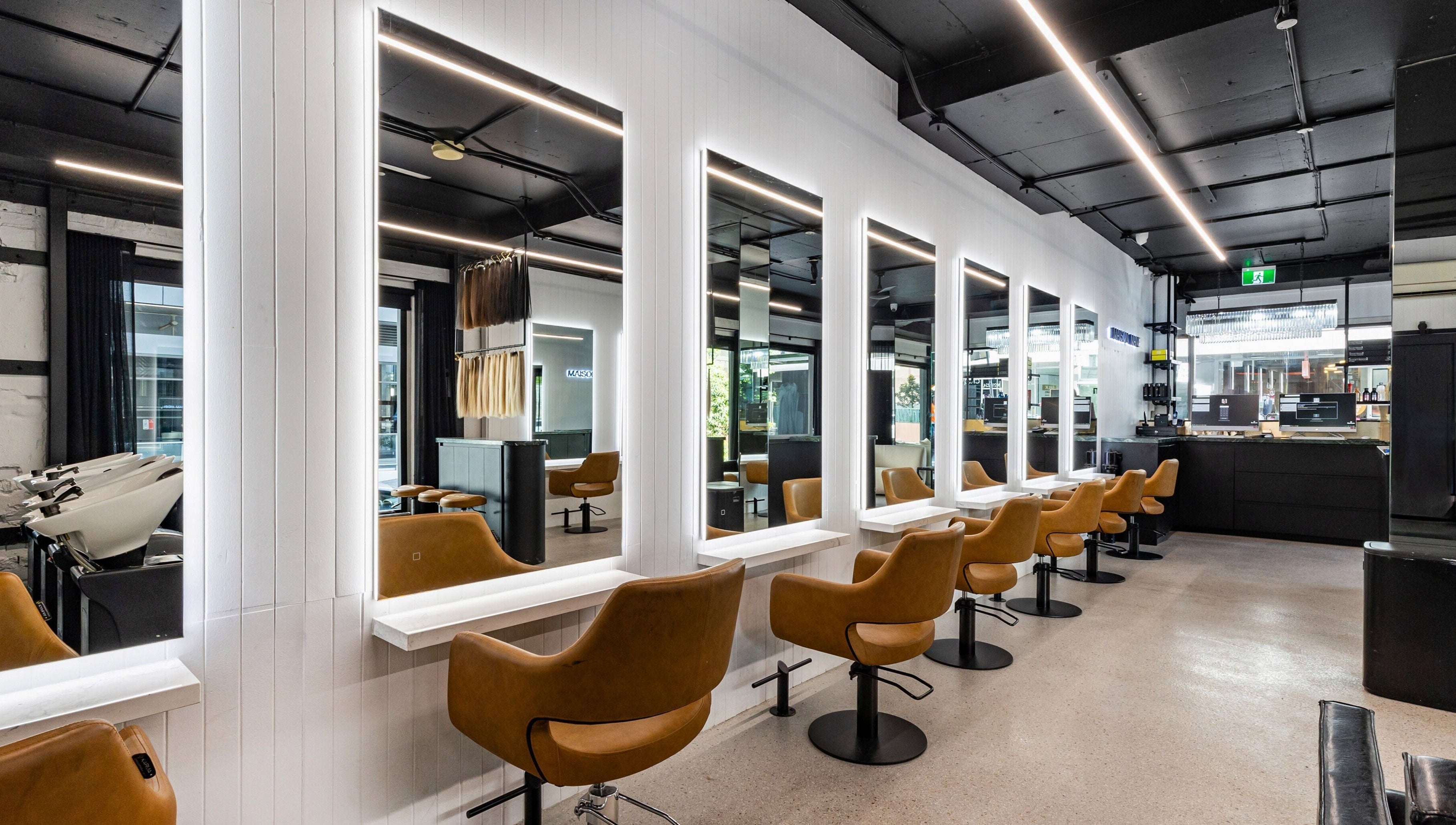 Interior view of MAISON MANE HAIR salon in Bondi Junction, New South Wales, AU showcasing modern seating and mirrors.