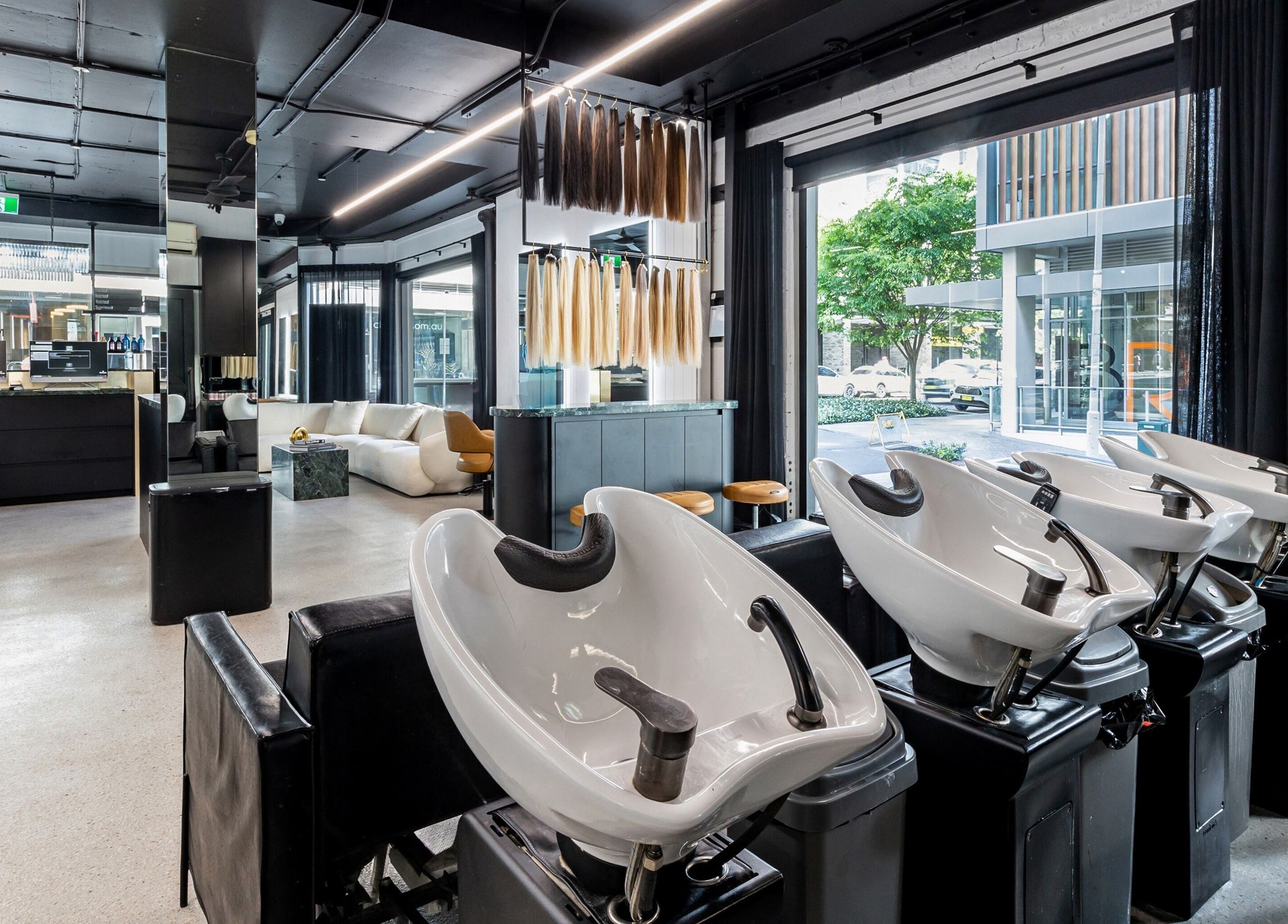 Modern interior of MAISON MANE HAIR in Bondi Junction, New South Wales, AU with stylish salon chairs and wash basins.