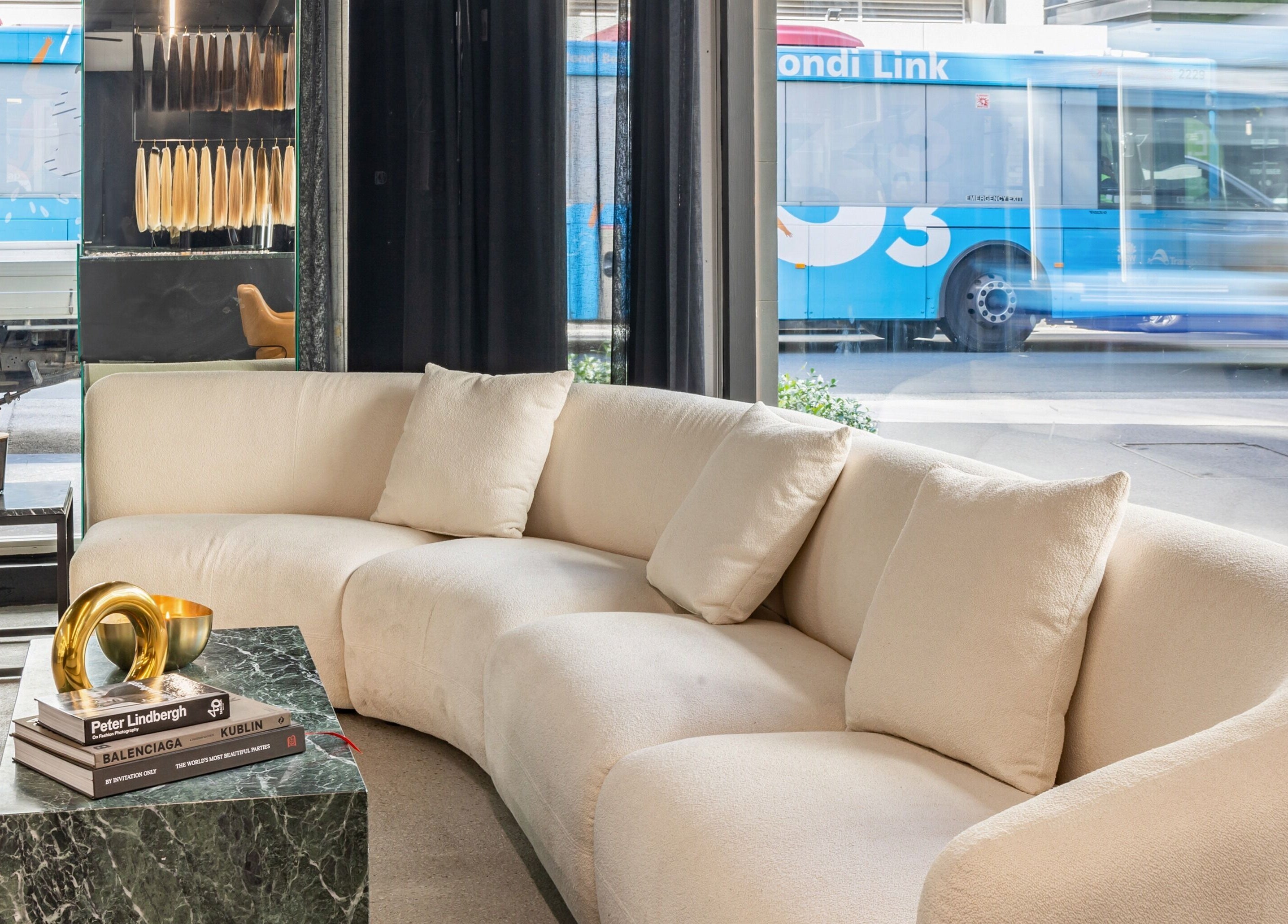 Elegant lounge area at MAISON MANE HAIR, Bondi Junction, New South Wales, AU, with cream sofa and modern decor.