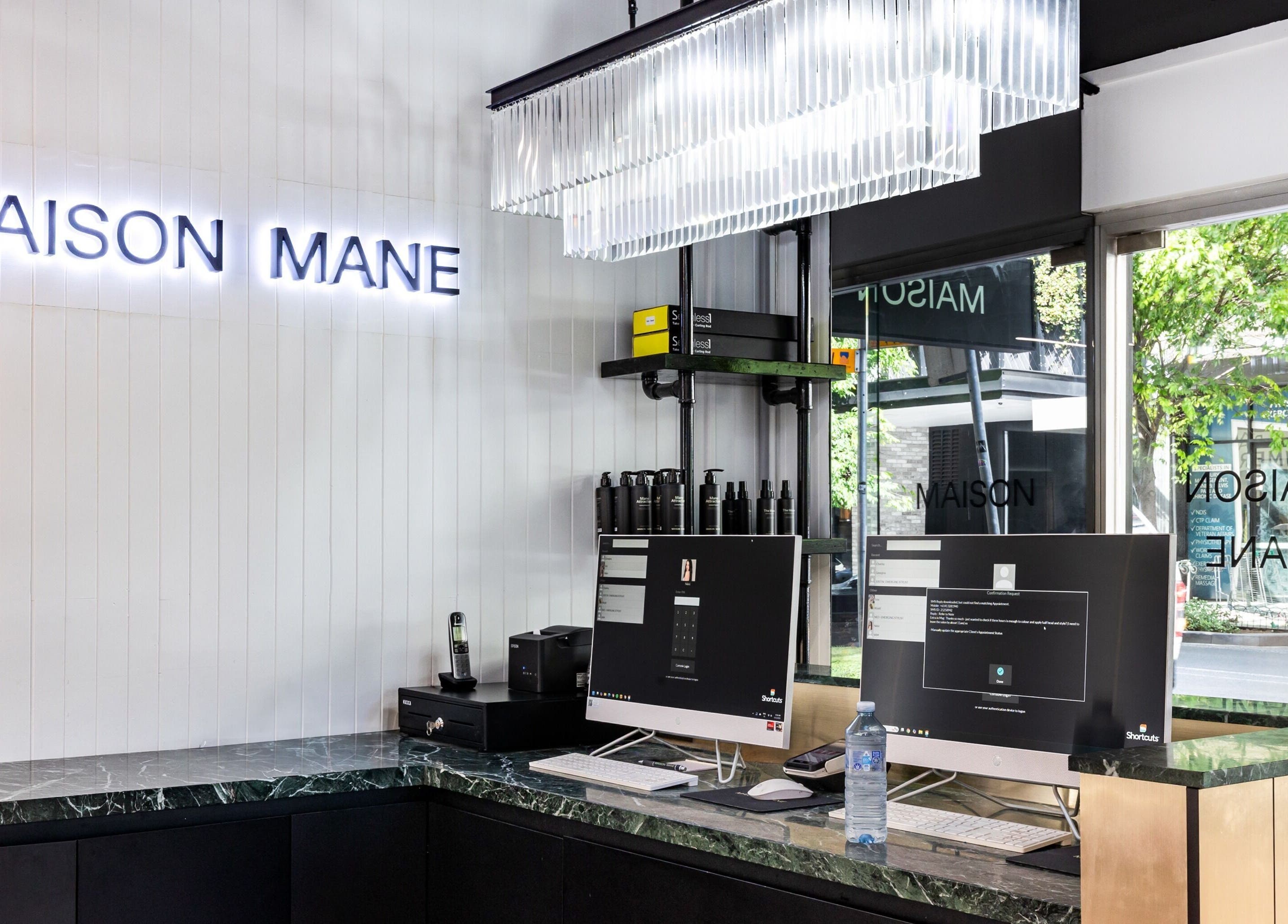 Reception area at MAISON MANE HAIR, Bondi Junction, New South Wales, AU with modern decor and sleek computers.