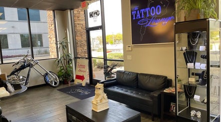 Interior of The Tattoo Lounge in Mesa, Arizona, US, featuring a sleek black couch and a display case with jewelry.