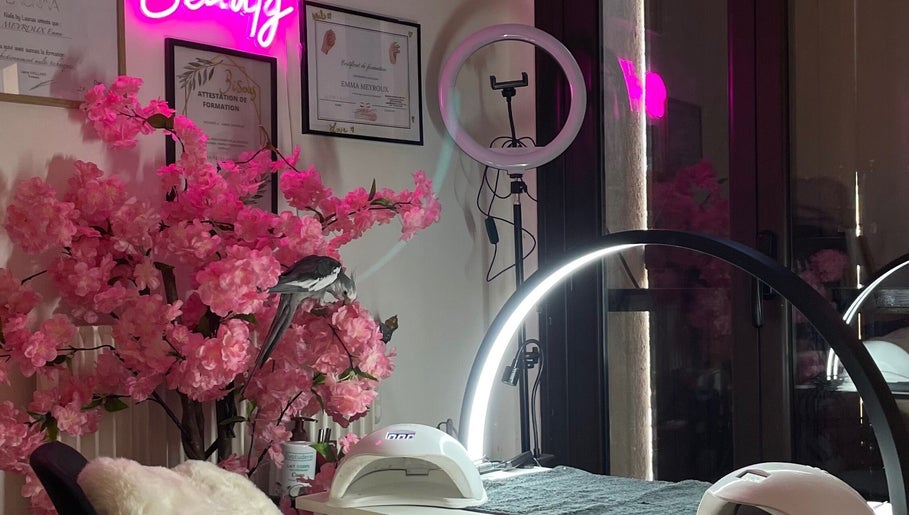 Intérieur chic de MK BEAUTY à Rivesaltes, Occitanie, FR avec décor floral rose et lumière néon.