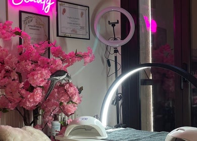 Intérieur chic de MK BEAUTY à Rivesaltes, Occitanie, FR avec décor floral rose et lumière néon.