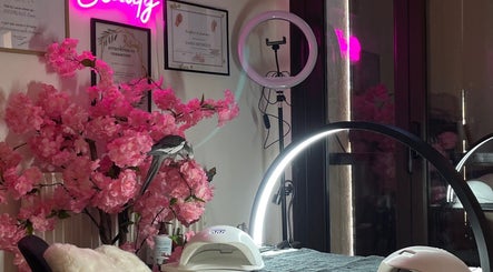 Intérieur chic de MK BEAUTY à Rivesaltes, Occitanie, FR avec décor floral rose et lumière néon.
