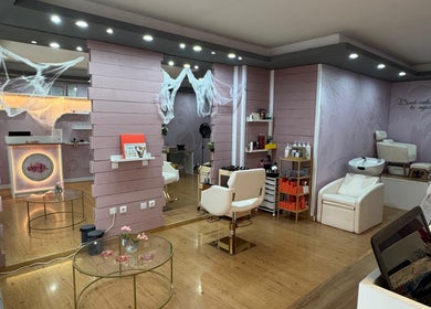 Interior moderno de Aurora Beauty Salon en Valladolid, Castilla Y León, ES, mostrando sillas y tocadores elegantes.