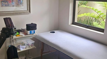 Calm treatment room at Island Aesthetics in Cape Town, Western Cape, ZA, featuring a massage table by a window.