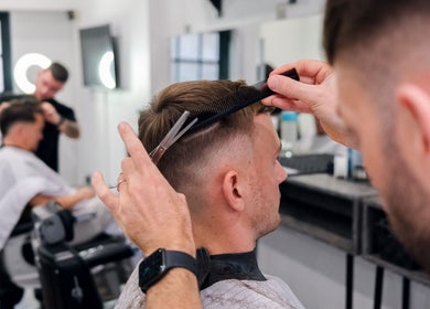Stylist at Prestige Salon in Lancaster, England, GB, perfecting a modern men's haircut in a chic setting.