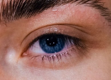 Close-up of a blue eye accentuated by well-groomed brows at Prestige Salon, Lancaster, England, GB.