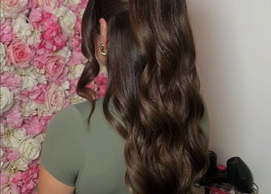 Elegant wavy hairstyle crafted at Larose Hair Studio, High Wycombe, England, GB, with floral backdrop.