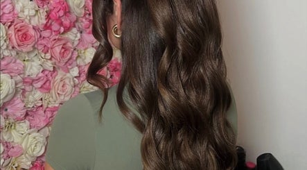 Elegant wavy hairstyle crafted at Larose Hair Studio, High Wycombe, England, GB, with floral backdrop.