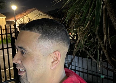 Man showcasing fresh fade haircut at Massie’s Barber Shop, Stellenbosch, Western Cape, ZA, in the evening.