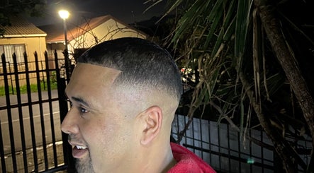 Man showcasing fresh fade haircut at Massie’s Barber Shop, Stellenbosch, Western Cape, ZA, in the evening.