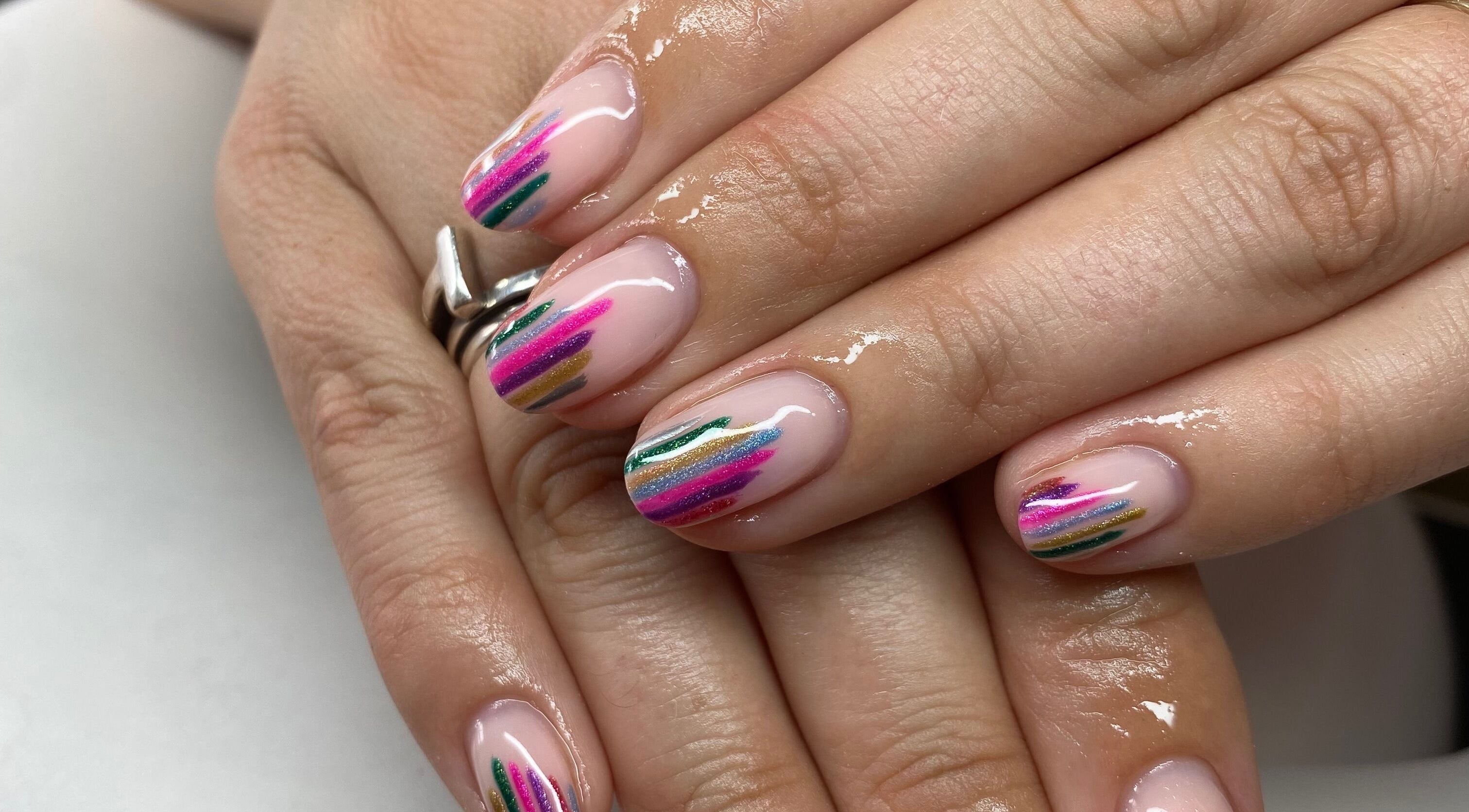 Vibrant nail art at Treatments by Holly, Thornbury, England, GB, showcasing colorful striped gel design.