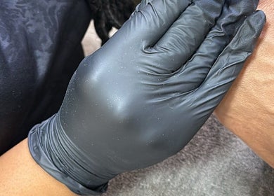 Gloved hand providing therapeutic treatment at Bella Escape Beauty Salon, Willemstad, CW for a rejuvenating experience.