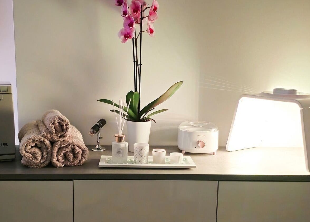 Een serene wellnesshoek met handdoeken en een orchidee bij Luxim Clinic, Antwerpen, Vlaanderen, BE.