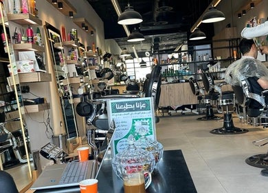 Modern salon interior at Wakar Al Chaib, Riyadh, Riyadh Province, SA, featuring stylish seating and shelves.