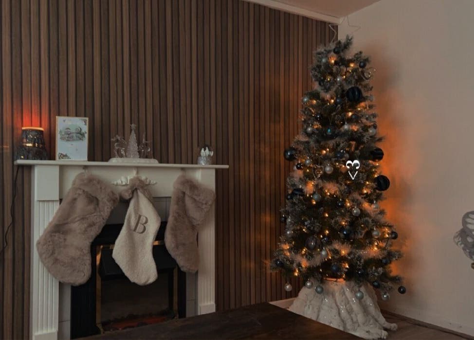 Elegant holiday setup at LF Beautyy in Dundonald, Northern Ireland, GB with a lit Christmas tree and decorated mantel.