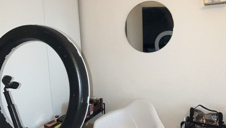 Espace maquillage moderne chez Flawless Touch, Toulouse, Occitanie, FR, avec chaise blanche et miroir rond.