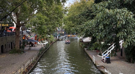 Scenic view of Utrecht canal near Beauty en Relax Massage Sugaring Salon, Utrecht, NL surrounded by lush greenery.