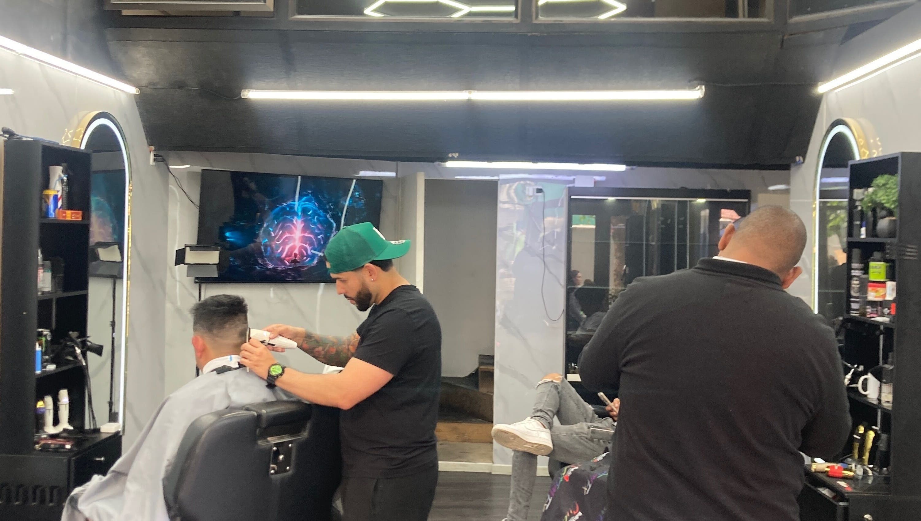 Barbero trabajando en Barberosamuel, Valparaíso, Valparaíso, CL, ofreciendo un corte moderno.