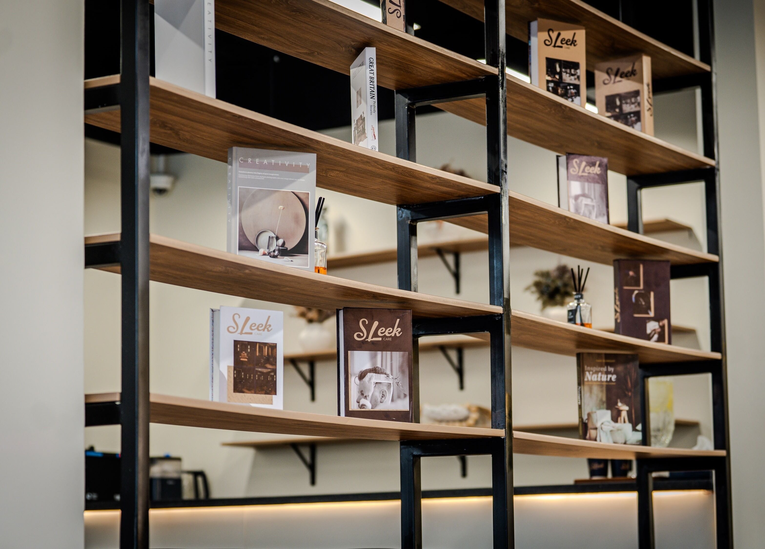 Elegant wooden bookshelf at Sleek Care, Riyadh, Riyadh Province, SA displaying decor and books.