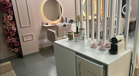 Interior sofisticado do Medeiros Hair Studio em São Paulo, BR, com espelhos iluminados e decoração floral.
