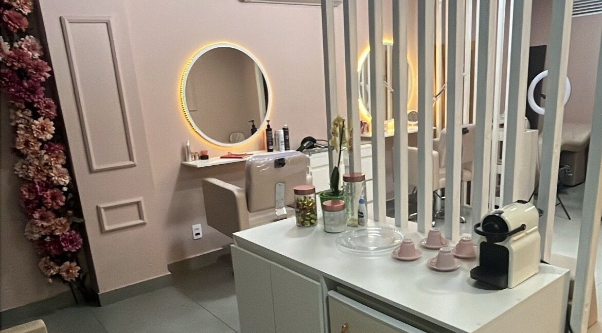 Interior moderno do Medeiros Hair Studio em São Paulo, com espelhos iluminados e decoração elegante.