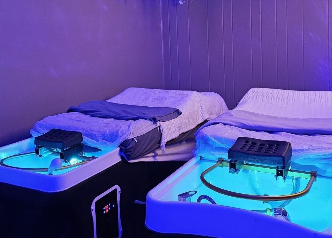 Tranquil massage beds at The Sculpting Art Day Spa in Hendersonville, TN, US, in a serene, blue-lit room.