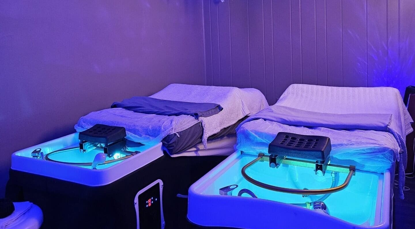 Aqua massage beds at The Sculpting Art Day Spa in Hendersonville, TN, US, glowing in soothing blue light.
