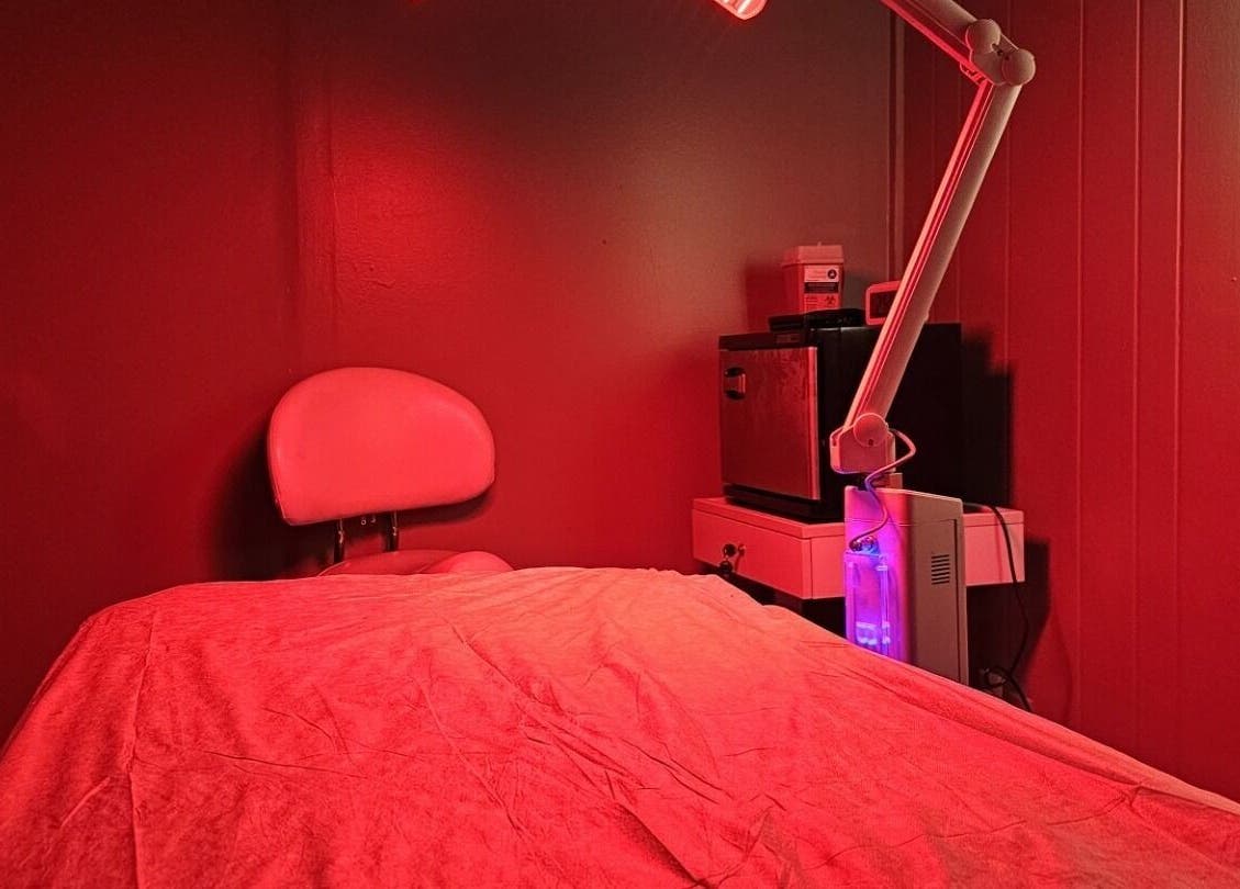 Relaxing massage room with soft red lighting at The Sculpting Art Day Spa, Hendersonville, TN, US.