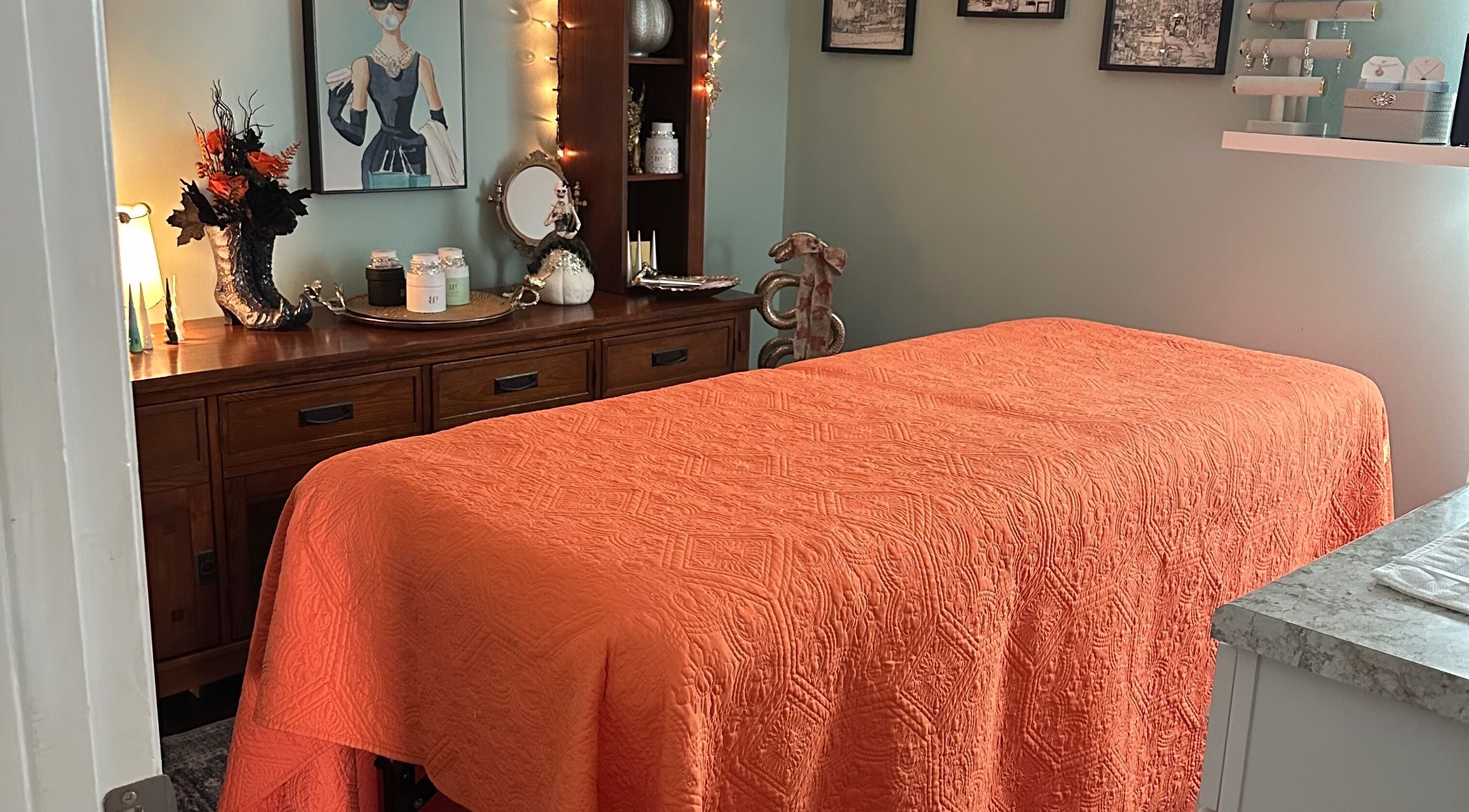 Tranquil massage room at Falling Waters Massage, Mad Lasher studio, Wilmington, NC, with orange decor.