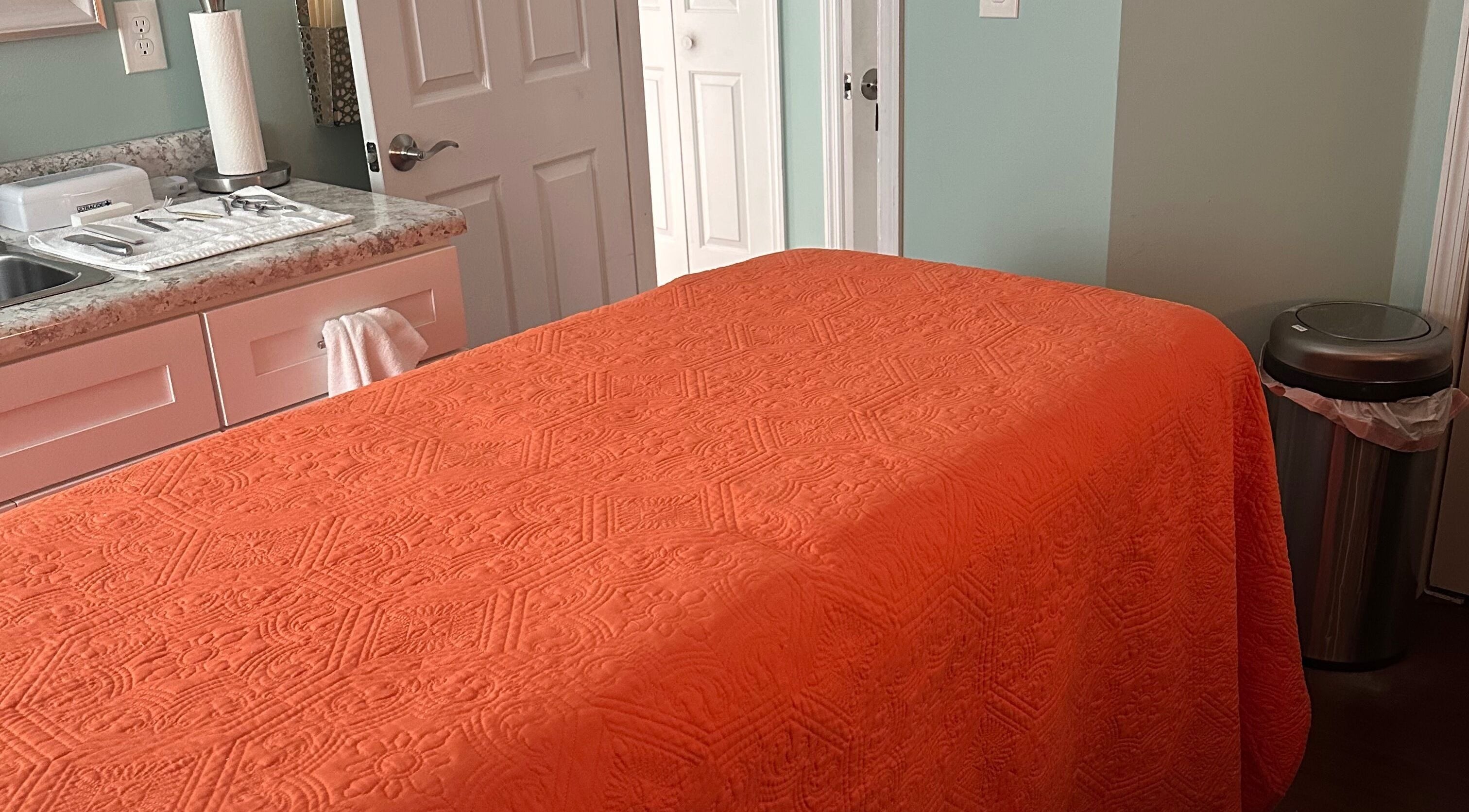Massage table with orange cover at Falling Waters Massage, Mad Lasher studio, Wilmington, North Carolina, US.
