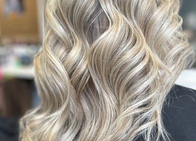 Blonde wavy hairstyle from R & R Hair Studios in Cardross, Scotland, GB showcases expert coloring and styling.
