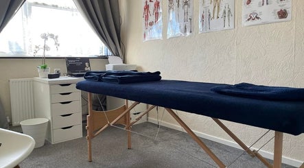 Massage room at Pain Therapy- massage, Houghton Regis, England, GB with a cozy table and soothing decor.