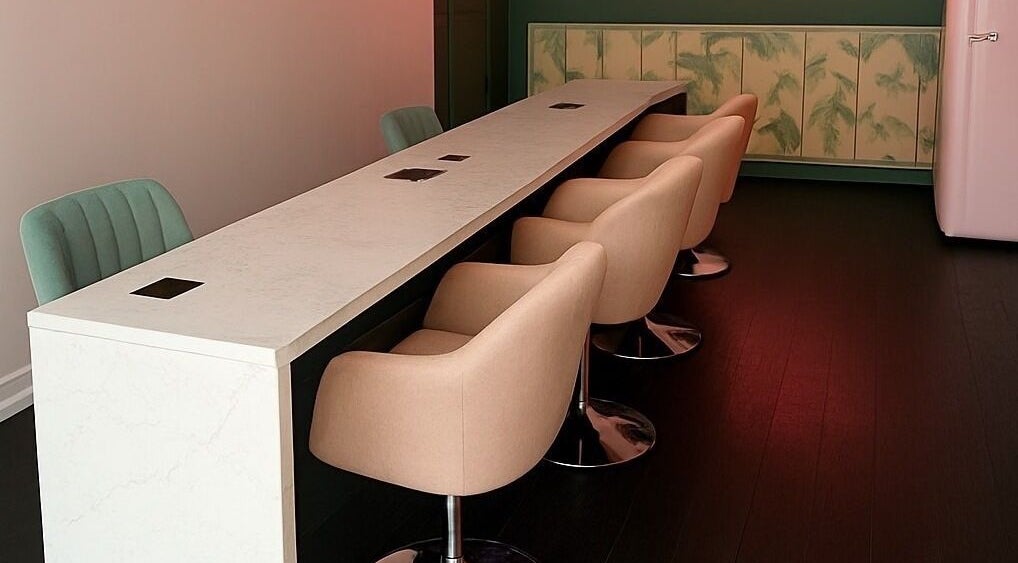 Sleek nail bar setup at THE DOLL HOUSE NAILS, Bristol, England, GB with modern seating and elegant decor.