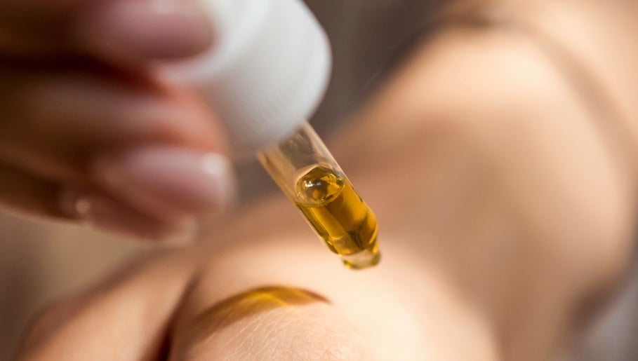 A dropper dispensing golden oil at Demo Salon, Coimbra, Coimbra, PT, reflecting wellness and skincare.