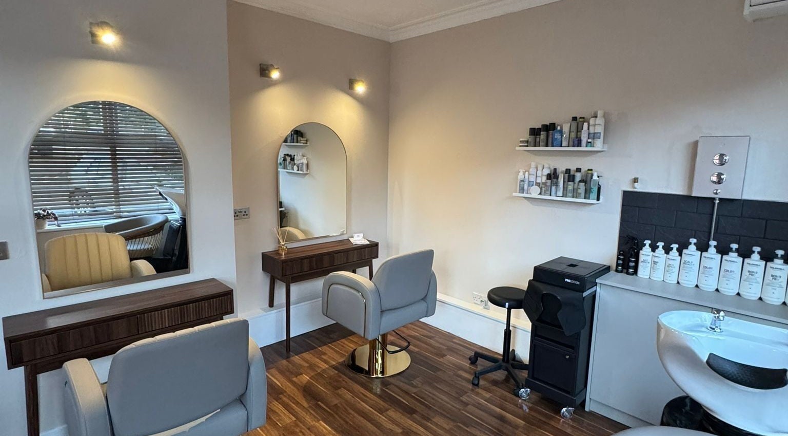 Sleek salon styling area at JG Hair Company, Yeovil, England, GB with modern chairs and mirrors.