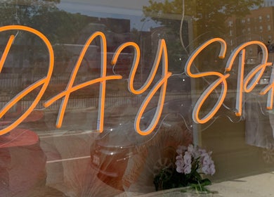 Neon 'Day Spa' sign at Sky Spa Laser, Forest Hills, New York, US, viewed from outside reflecting street.