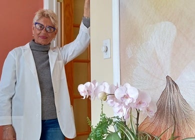 A welcoming staff member at Sky Spa Laser, Forest Hills, New York, US, with orchids and vibrant decor.