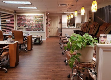 Cozy interior of Quality Nails Spa in Hingham, MA, US with manicure stations and soothing decor.