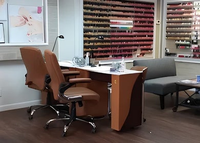 Cozy interior of Belle Nails & Lashes Hingham, showcasing elegant chairs and nail polish display in Hingham, MA, US.