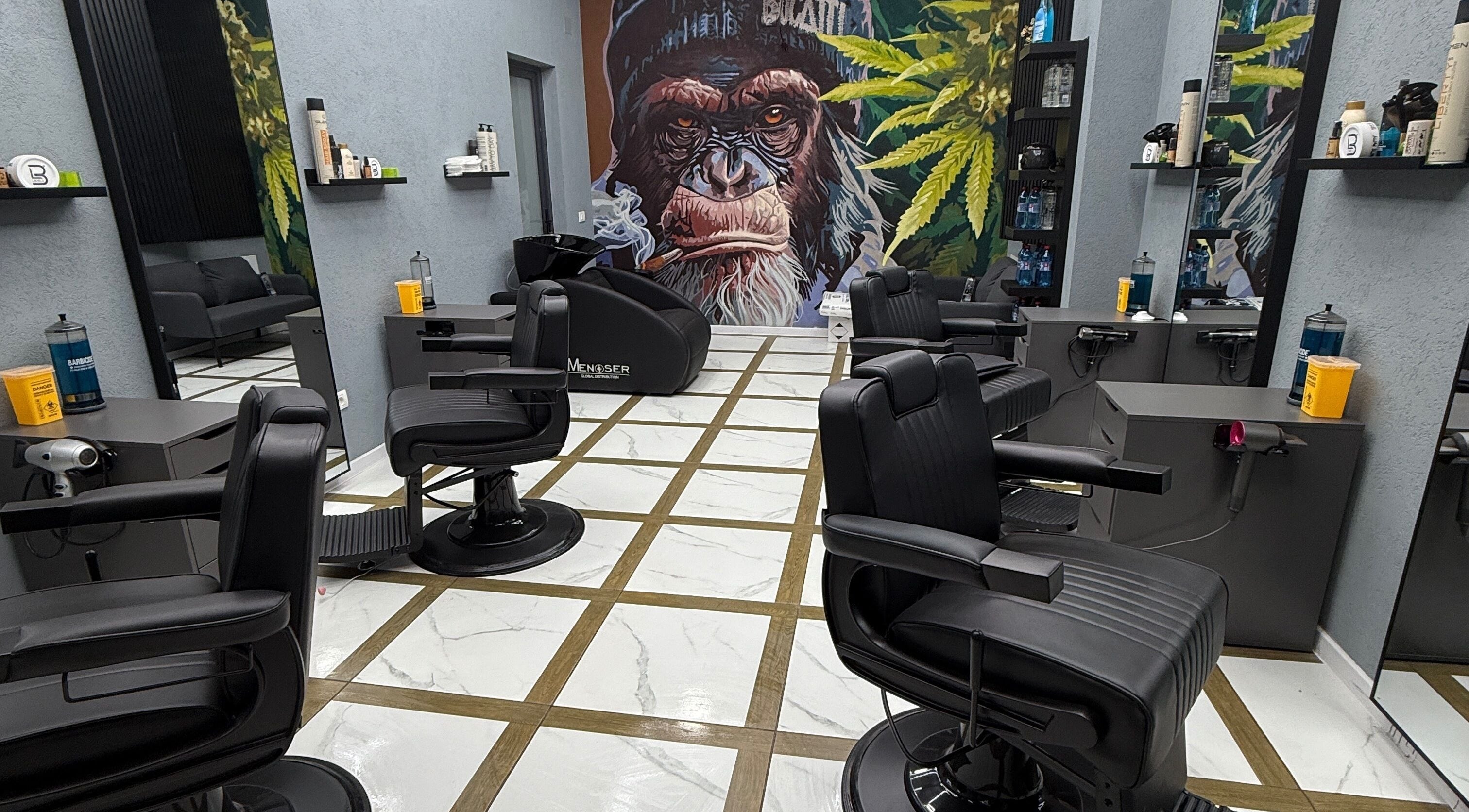 Interior modern al BUCATTI BARBERSHOP BY EL NINO, Popești-Leordeni, cu scaune și decor vibrant.