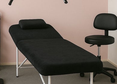 Salon de masaj la Next Touch Studio, Bootle, England, GB, cu pat modern și scaun confortabil.