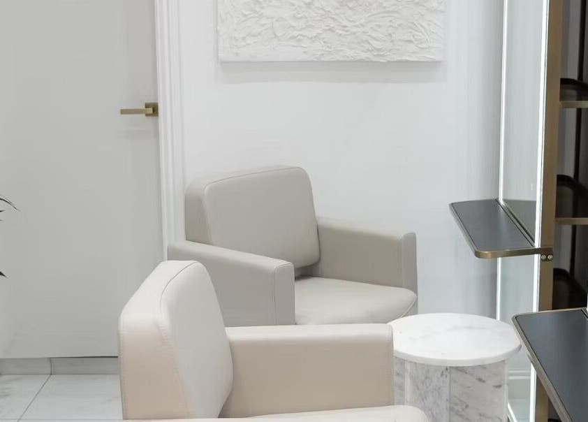 Modern, elegant salon interior at Tresses By Em in GB, featuring plush seating and stylish decor.