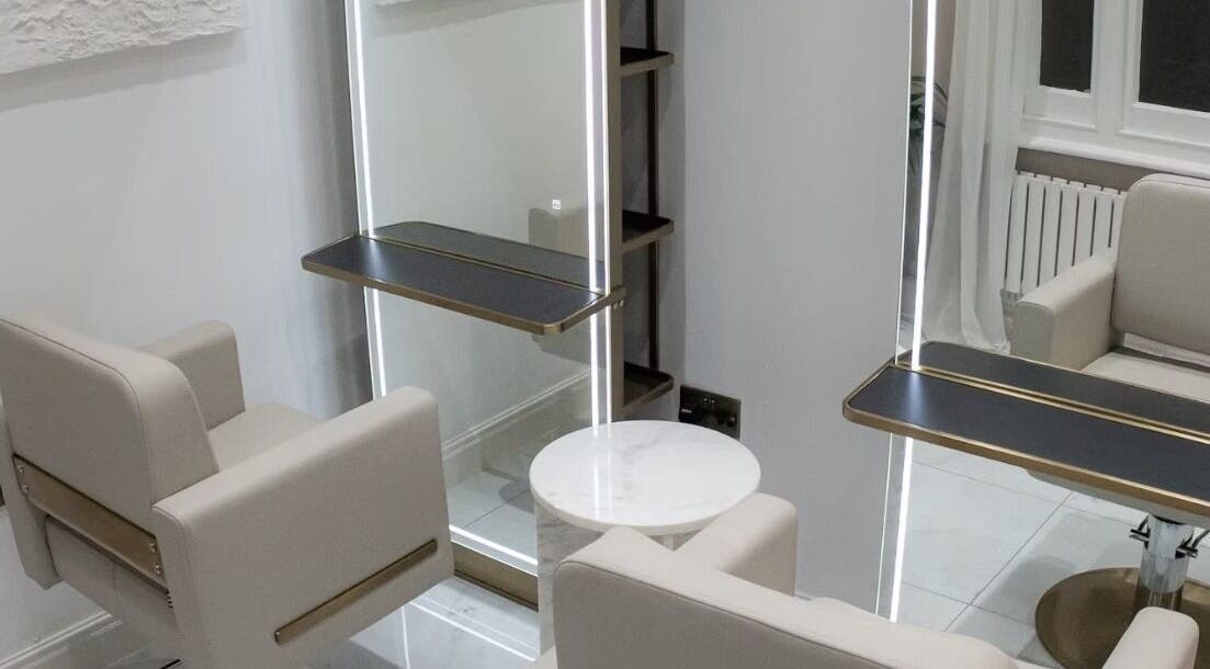 Elegant salon chairs and mirror at Tresses By Em, GB. Modern design with neutral tones and stylish lighting.