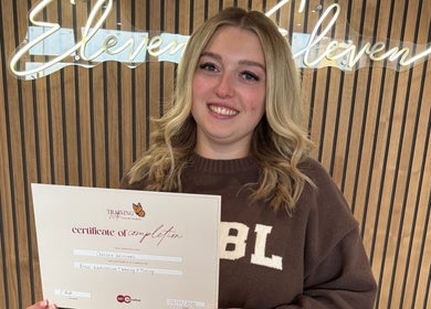 Graduate proudly holding a certificate at Chelsea Beauty Artistry, Prestatyn, Wales, GB.