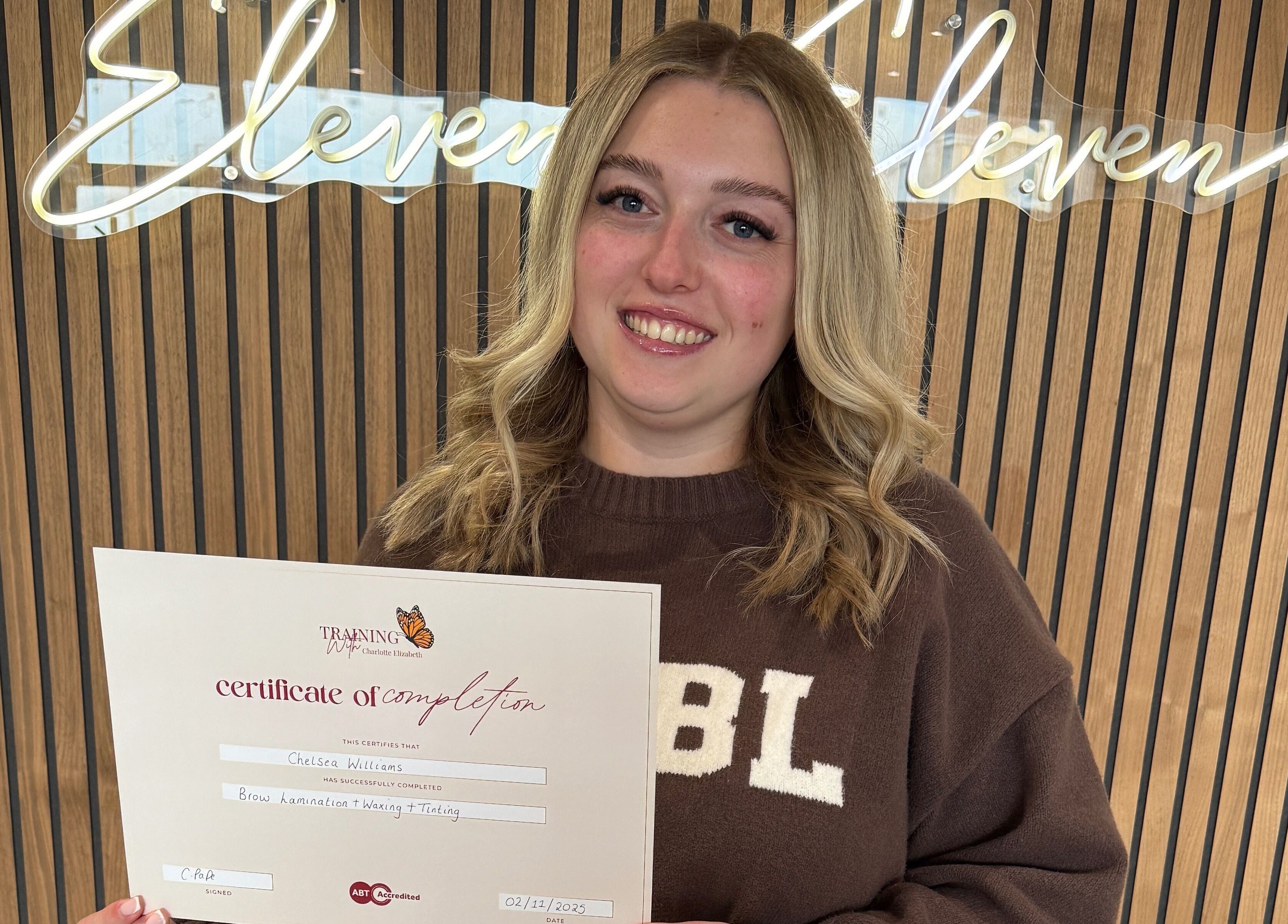 Graduate proudly holding a certificate at Chelsea Beauty Artistry, Prestatyn, Wales, GB.