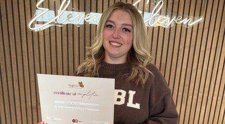 Graduate proudly holding a certificate at Chelsea Beauty Artistry, Prestatyn, Wales, GB.