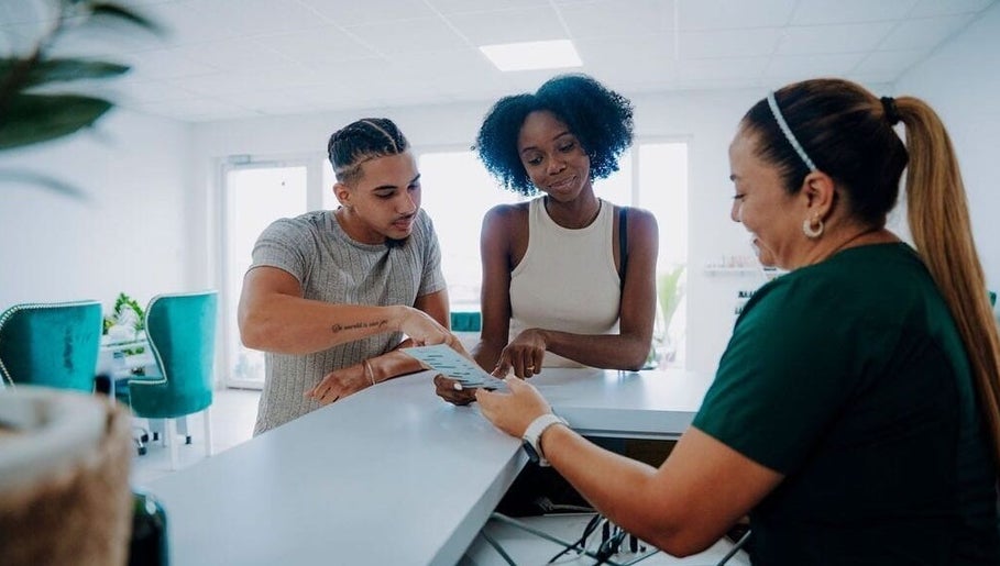 Guests discussing spa services with receptionist at Kundalini Spa Aruba, Noord, US.