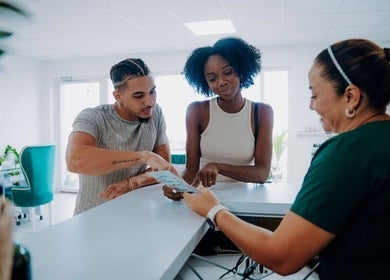 Guests discussing spa services with receptionist at Kundalini Spa Aruba, Noord, US.